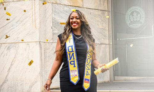 Herzing DNP graduate Carla Bourelly smiling with diploma 